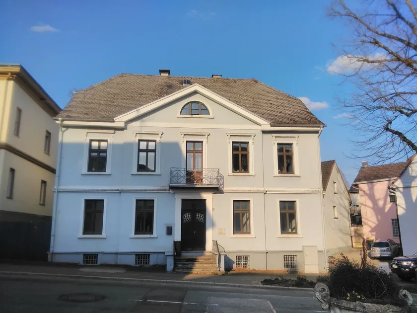Klassisches Stadthaus mit hellblauer Fassade und Naturschieferdach