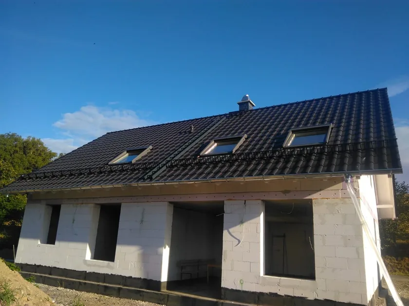 Wohnhaus mit mehreren Dachflächenfenstern in dunkler Eindeckung
