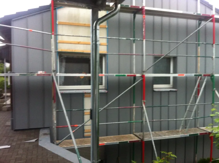 Fassadenverkleidung aus Metallpaneelen während der Montage am Gerüst