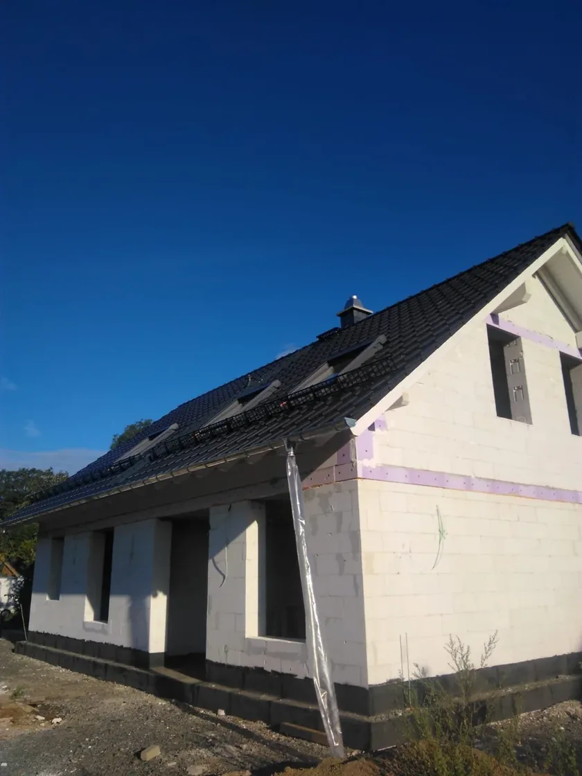Seitenansicht Neubau mit dunkler Ziegeldeckung und Giebel