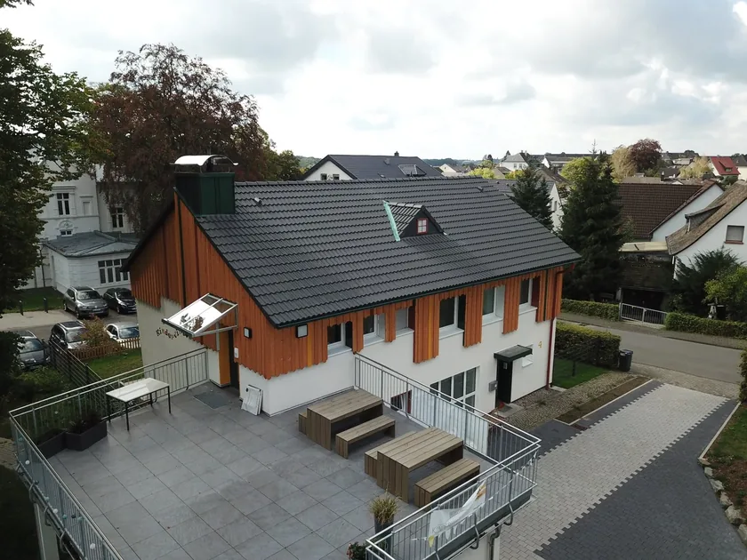 Wohngebäude mit dunklem Steildach und Holzfassade